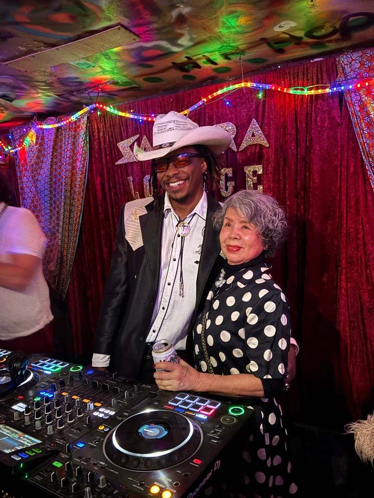Juan Lo posing beside DJ booth